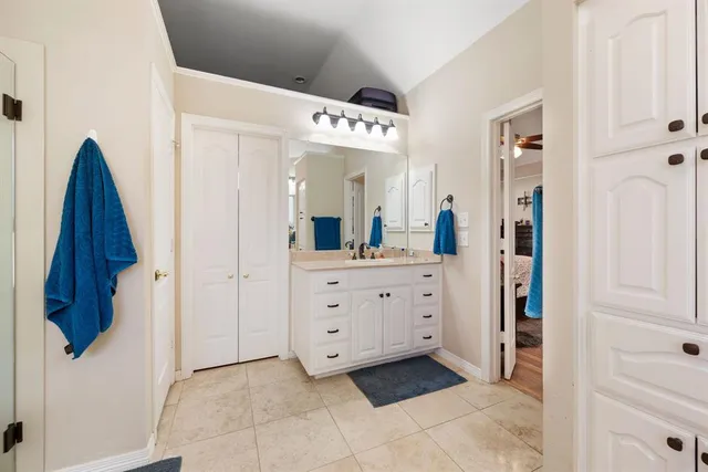 a spacious bathroom with a shower a sink and a mirror