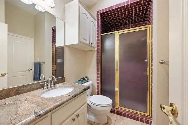 a bathroom with a granite countertop sink toilet and shower