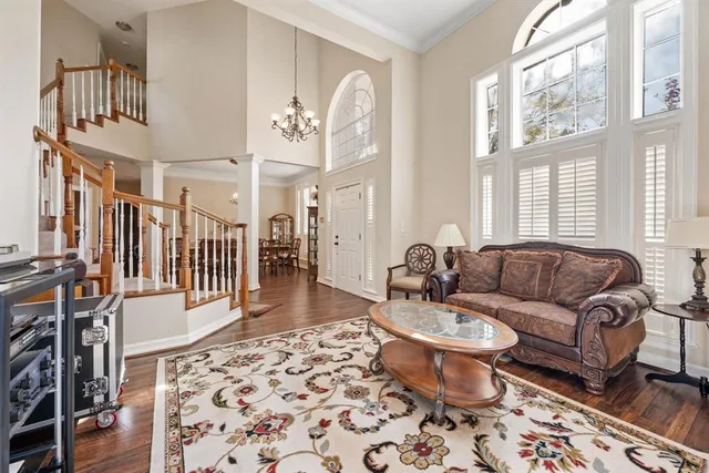 a living room with furniture a dining table and a chandelier