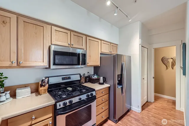 a kitchen with stainless steel appliances granite countertop a refrigerator stove and sink