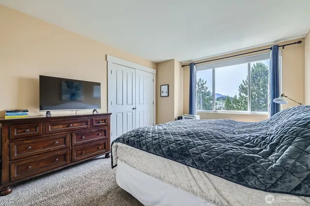 a bed sitting in a bedroom next to a window with dresser