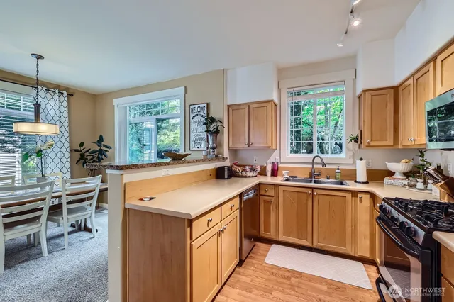 a kitchen with stainless steel appliances granite countertop sink stove top oven and cabinets