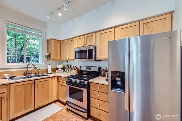 a kitchen with stainless steel appliances a refrigerator stove and sink