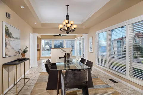 a view of a dining room with furniture a chandelier and wooden floor