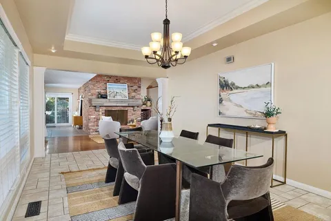 a view of a dining room with furniture and a chandelier