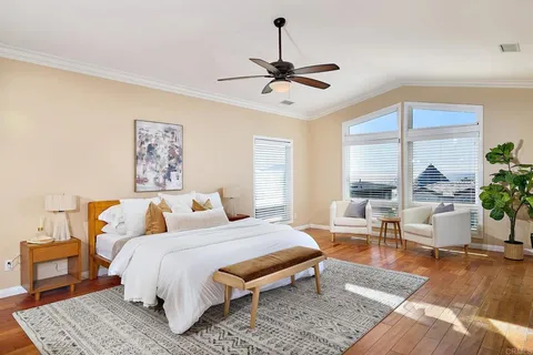 a spacious bedroom with a bed a table and window