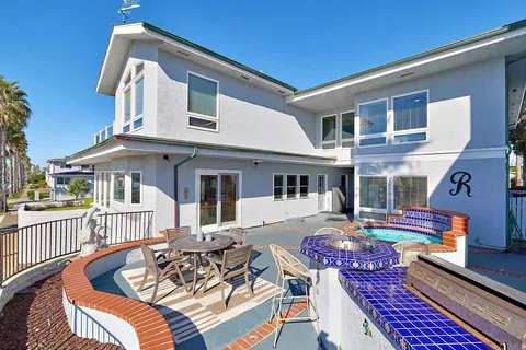 a view of a patio with couches chairs and wooden floor