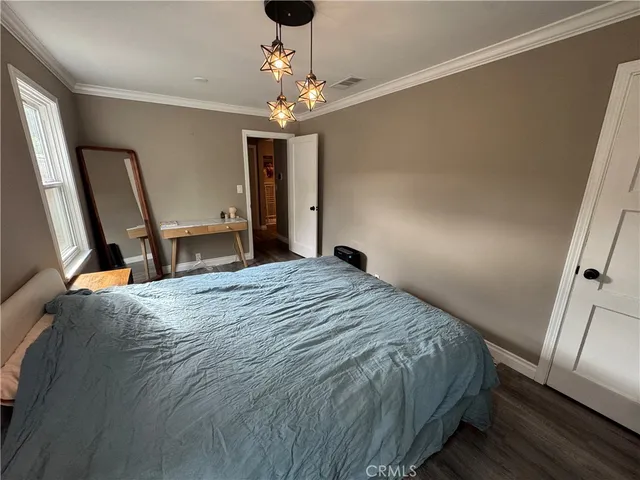 a bedroom with a bed and a chandelier