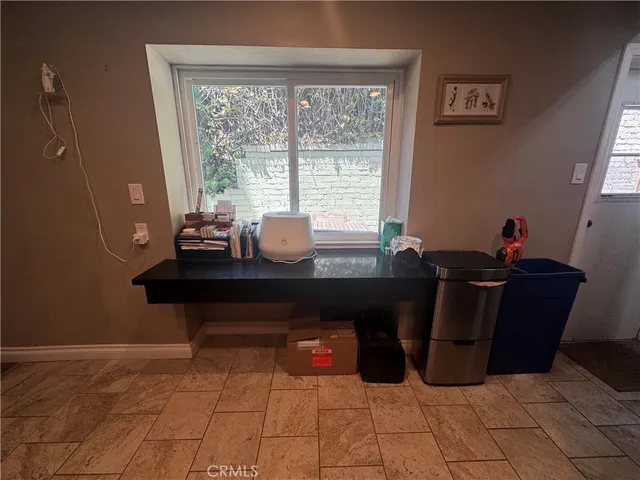 a room with a desk and a potted plant