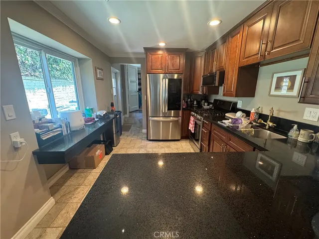 a kitchen with stainless steel appliances granite countertop a stove refrigerator and cabinets