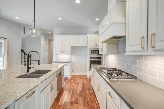a kitchen with stainless steel appliances granite countertop a sink stove and refrigerator