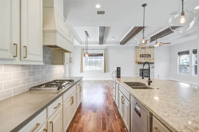 a kitchen with stainless steel appliances granite countertop a sink stove and cabinets