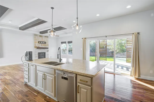 a open kitchen with a stove a sink a window and dining table
