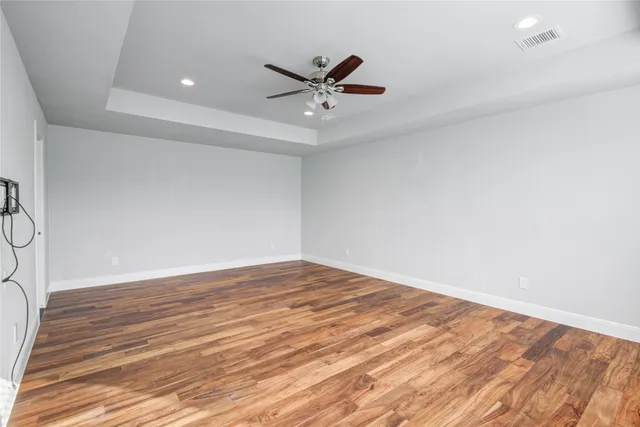a view of a livingroom with a ceiling fan and wooden floor