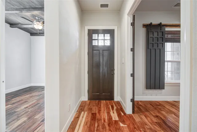 a view of a bedroom with wooden floor and a window