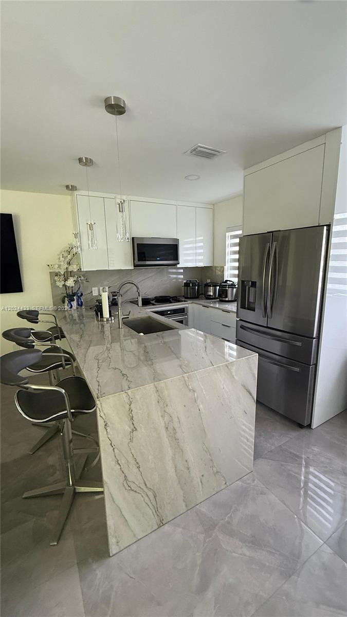 13675 Southwest 62nd Street, Unit 2023 Miami, FL 33183 - Photo 1 of 22 a kitchen with a sink a stove and refrigerator