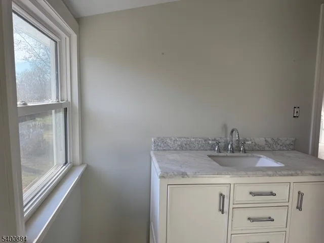 a bathroom with a granite countertop sink and vanity
