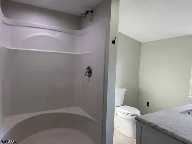 a bathroom with a granite countertop bathtub shower and toilet