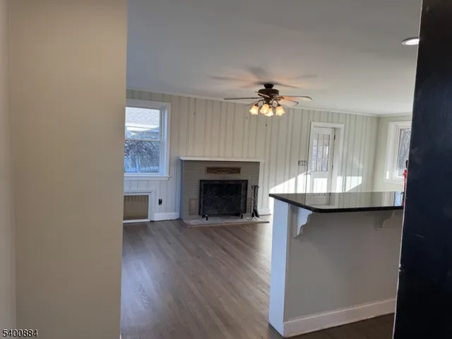 a view of a livingroom with a fireplace a chandelier and wooden floor