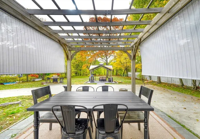 a view of a white house with a fountain and potted plants