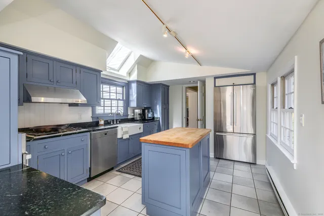 a kitchen with stainless steel appliances granite countertop a sink and a stove
