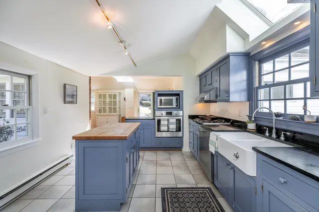 a large kitchen with stainless steel appliances granite countertop a stove and a sink