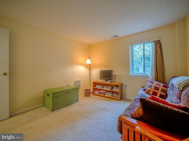 a living room with furniture and a air conditioner vent