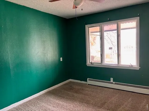 a view of a room with a window and a ceiling fan