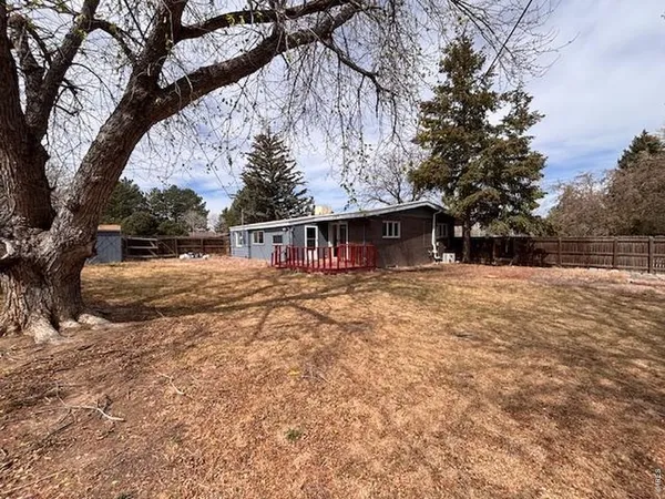 a view of a house with backyard and chairs