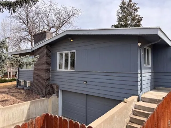 a side view of a house with wooden fence