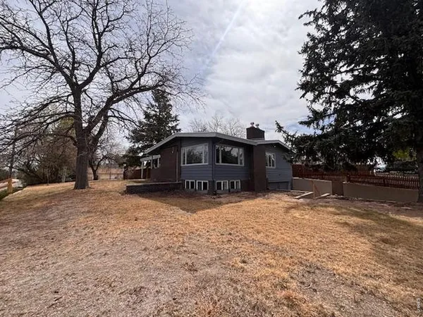 a front view of a house with a yard covered in snow
