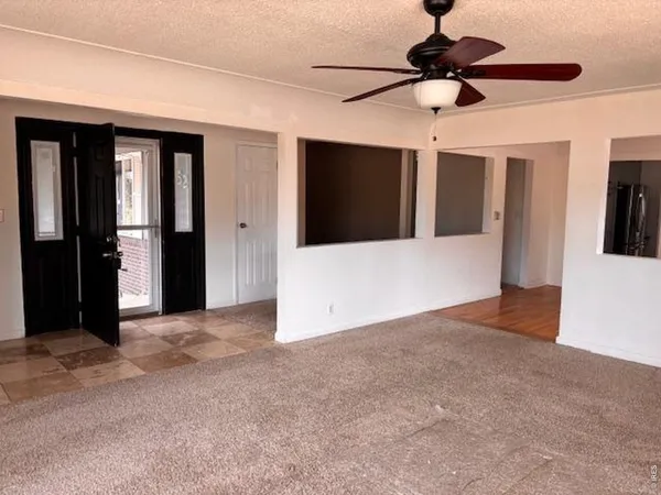 a view of an empty room with a ceiling fan