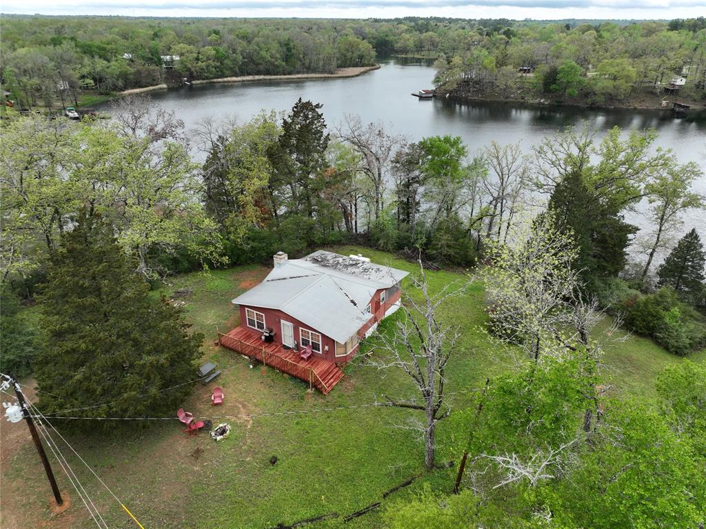 an aerial view of a house with pool lake and outdoor seating