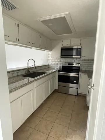 a kitchen with stainless steel appliances granite countertop a sink and cabinets