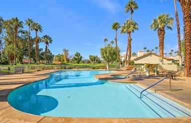 43885 Arancia Way Indio, CA 92203 - Photo 20 of 22 a view of a swimming pool with a table and chairs