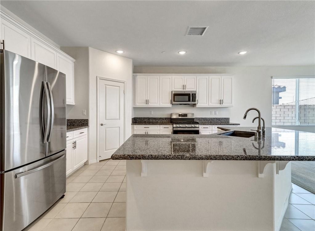 43885 Arancia Way Indio, CA 92203 - Photo 2 of 22 a kitchen with stainless steel appliances granite countertop a refrigerator a stove a sink a microwave and white cabinets