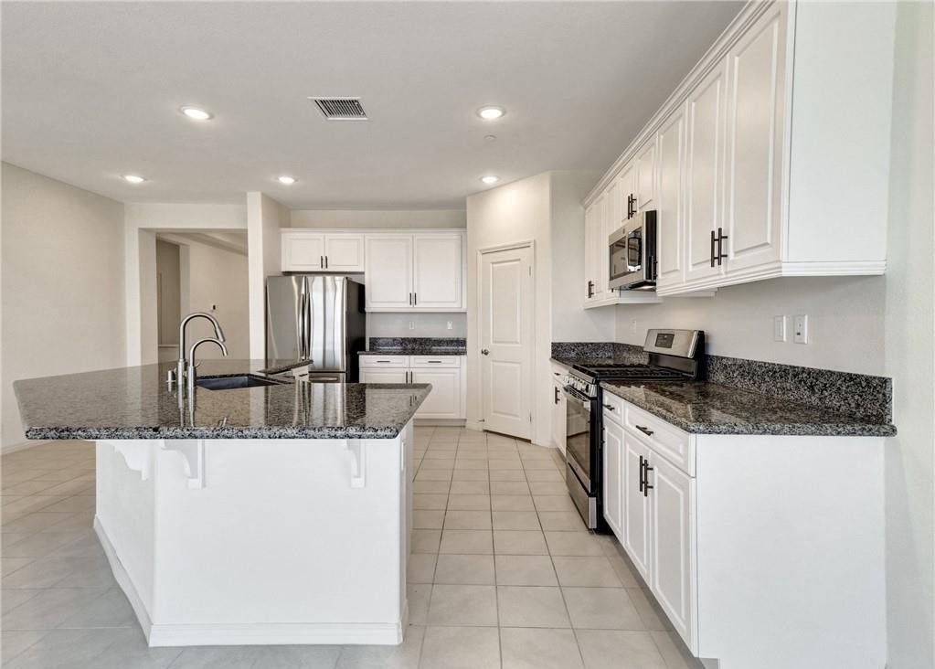 43885 Arancia Way Indio, CA 92203 - Photo 3 of 22 a large kitchen with stainless steel appliances granite countertop a sink a stove and a refrigerator
