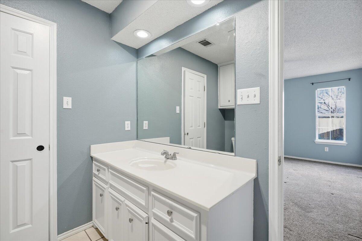 6214 6th Street Lubbock, TX 79416 - Photo 13 of 21 a bathroom with a sink vanity and a mirror