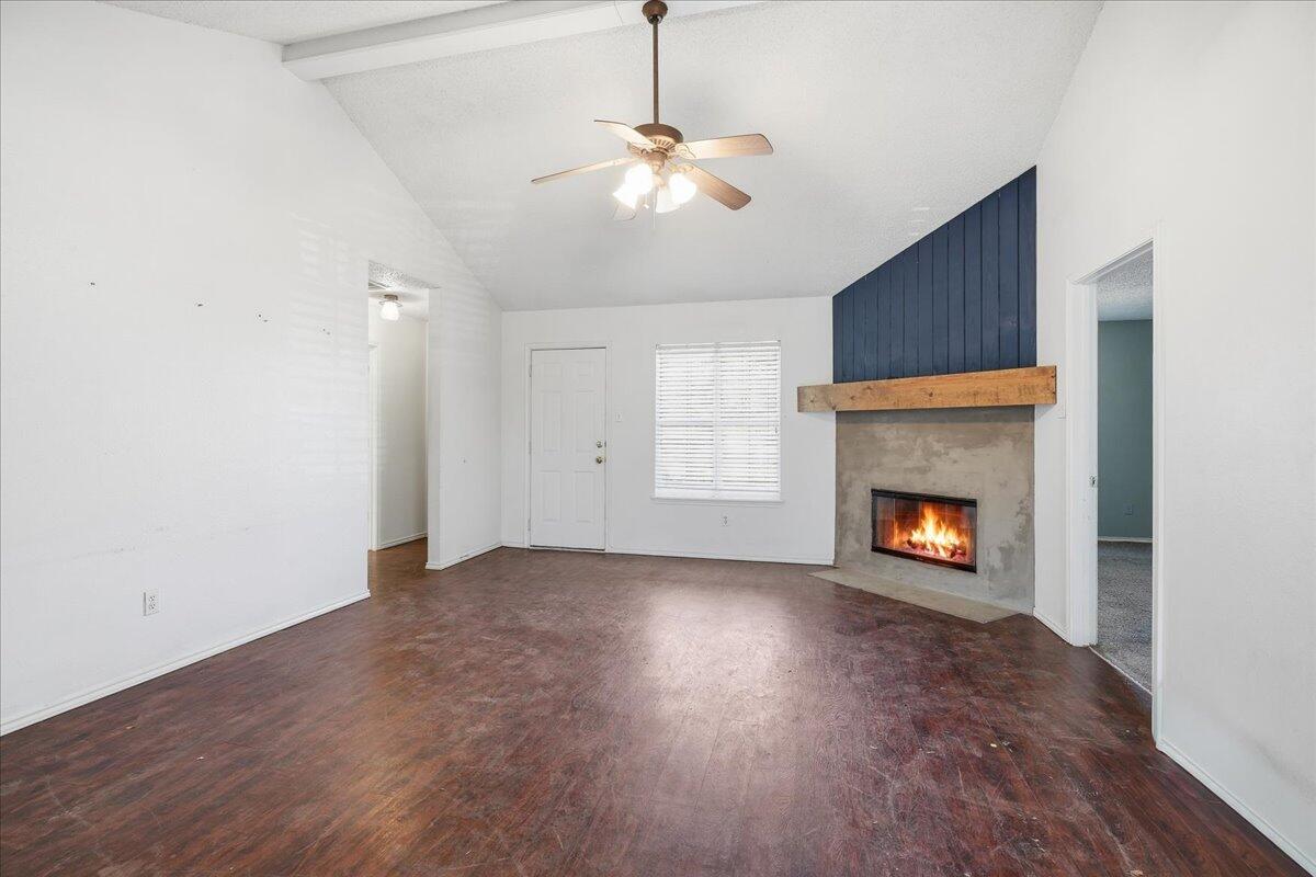 6214 6th Street Lubbock, TX 79416 - Photo 3 of 21 a view of an empty room with a fireplace and a window