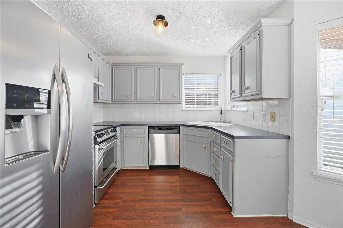 6214 6th Street Lubbock, TX 79416 - Photo 5 of 21 a kitchen with stainless steel appliances granite countertop a refrigerator sink and wooden cabinets