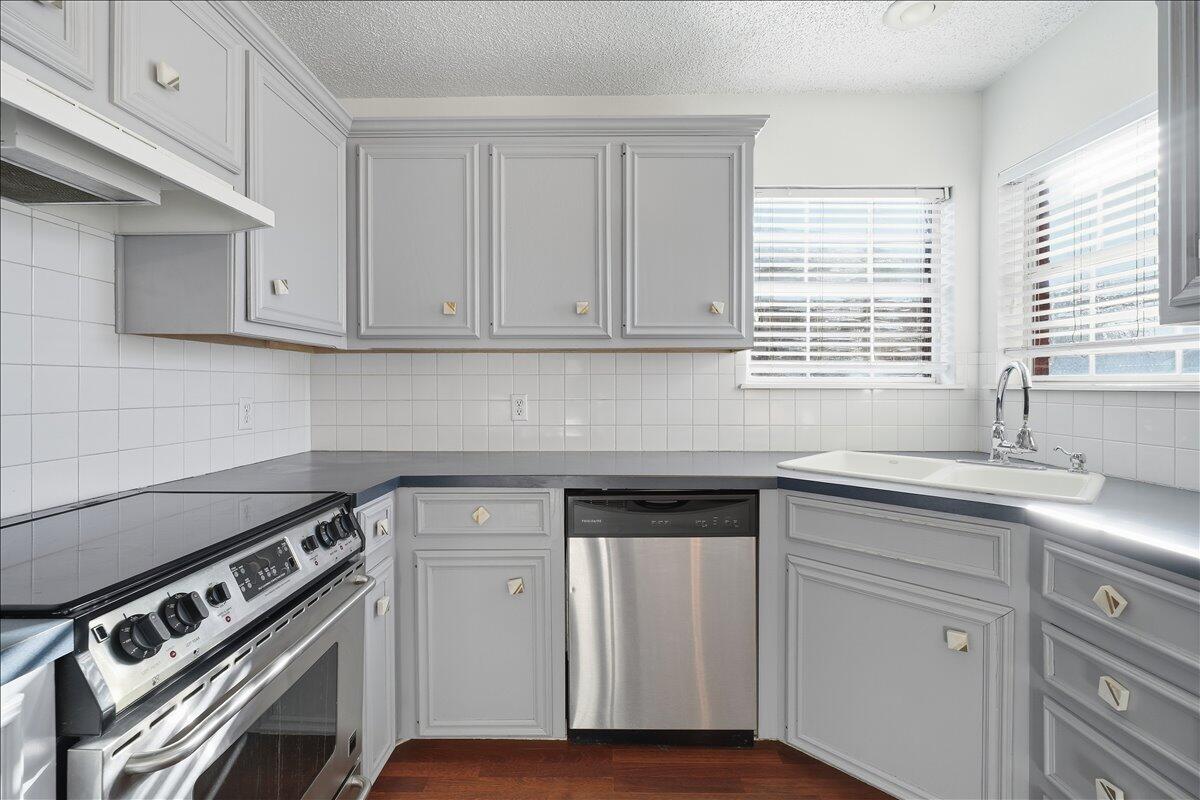 6214 6th Street Lubbock, TX 79416 - Photo 6 of 21 a kitchen with white cabinets and a stove top oven