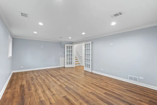 a view of empty room with wooden floor and windows