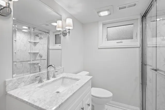 a bathroom with a sink a toilet and a mirror