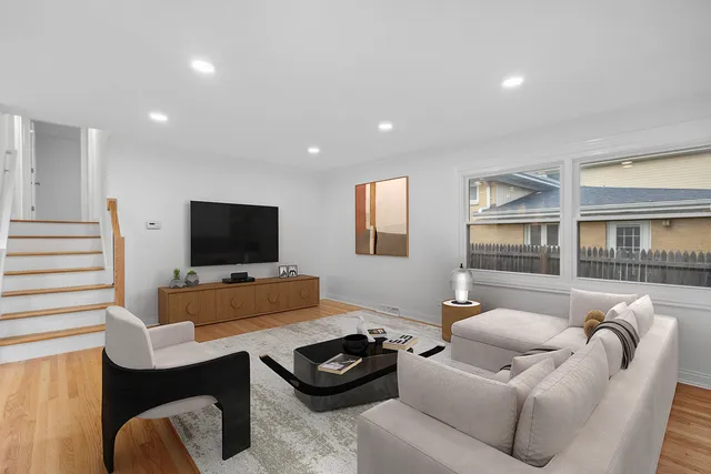 a living room with furniture a flat screen tv and a window