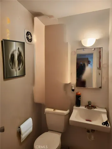 a bathroom with a toilet a sink and mirror