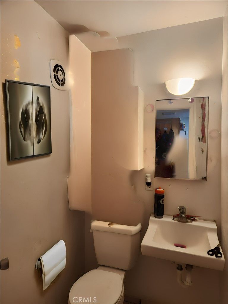 207 East Orchard Street, Unit C Santa Maria, CA 93454 - Photo 6 of 10 a bathroom with a toilet a sink and mirror