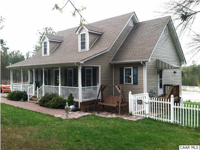 a view of a house with a yard and a large tree front of it