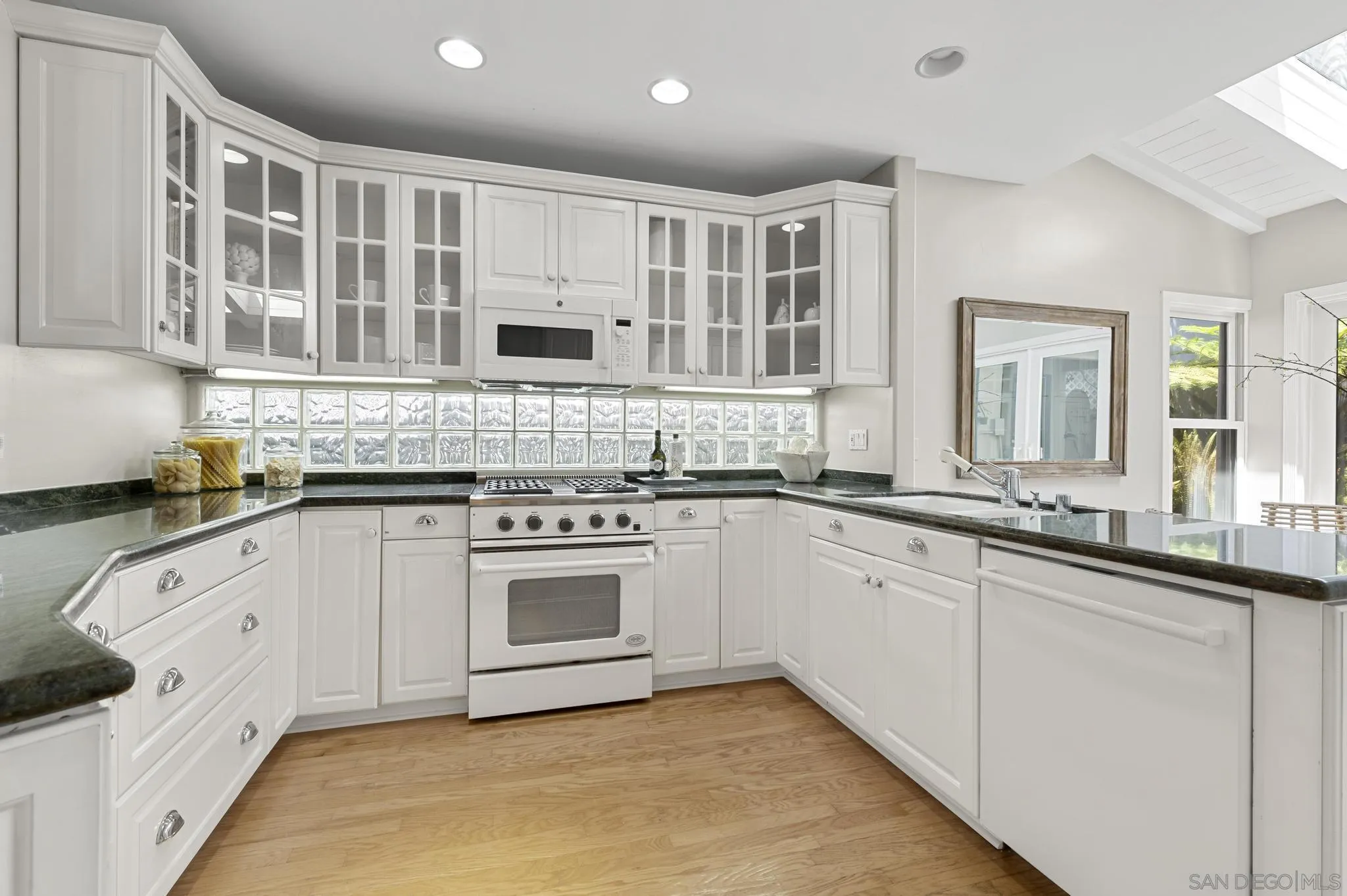 7231 Draper Avenue La Jolla, CA 92037 - Photo 8 of 26 a kitchen with granite countertop white cabinets and white appliances