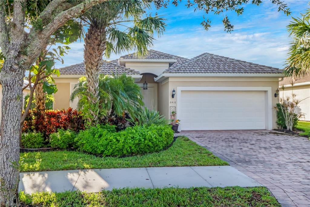 8416 Benelli Court Naples, FL 34114 - Photo 2 of 12 a front view of a house with a yard and garage