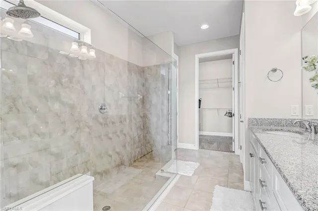 a bathroom with a granite countertop sink a mirror and shower